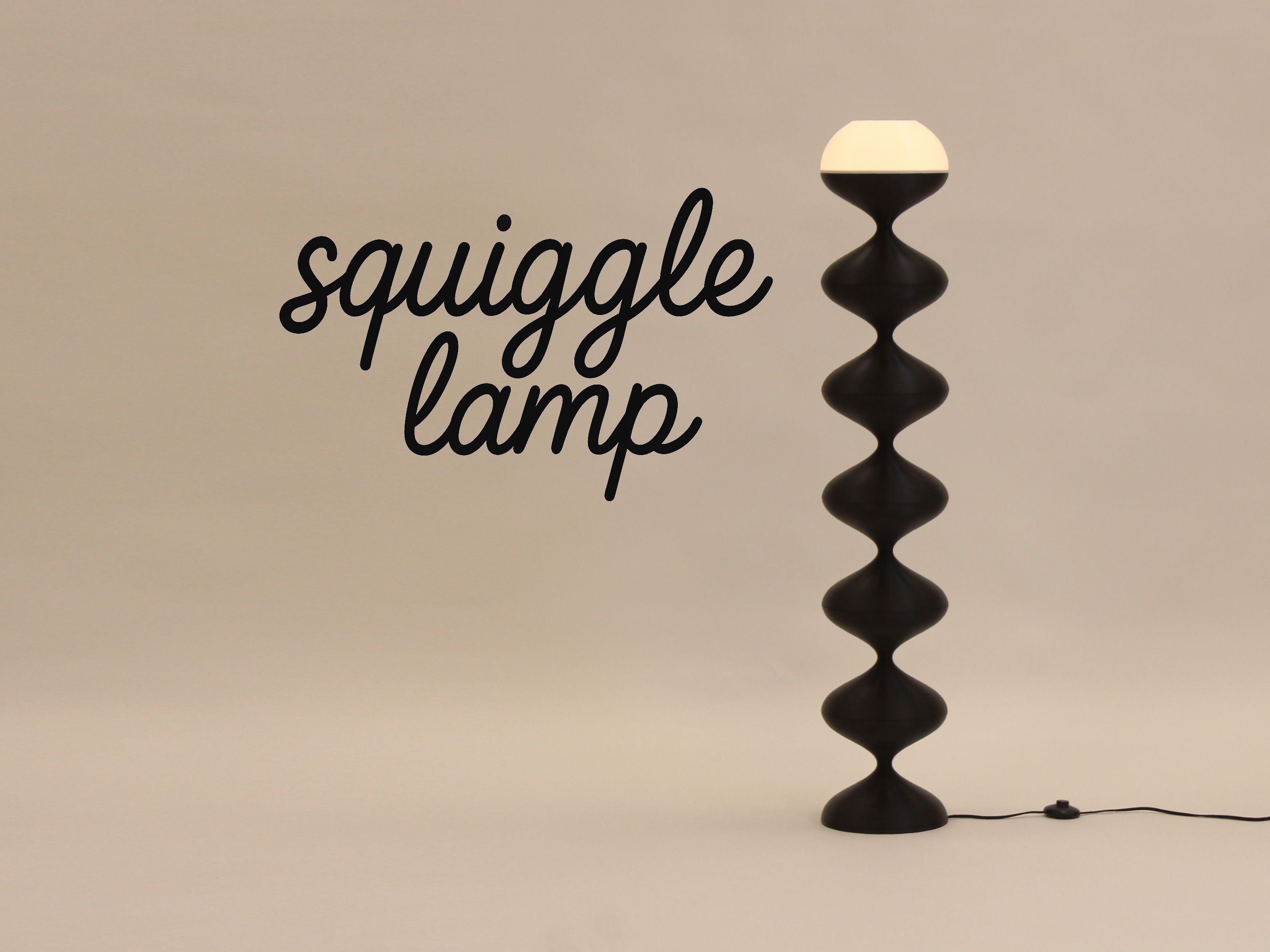 Squiggle Lamp logo beside the lit black floor lamp